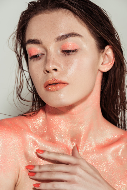 beautiful stylish girl with coral glitter makeup posing isolated on grey - Foto, afbeelding