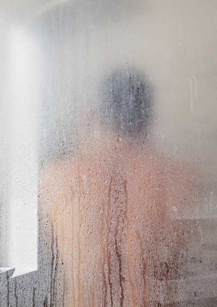 Silhouette of adult man in shower cabin - Fotoğraf, Görsel