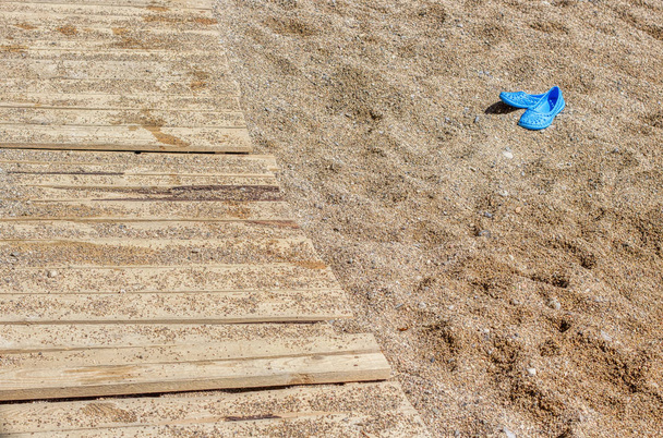chinelos na areia e praia ensolarada
 - Foto, Imagem