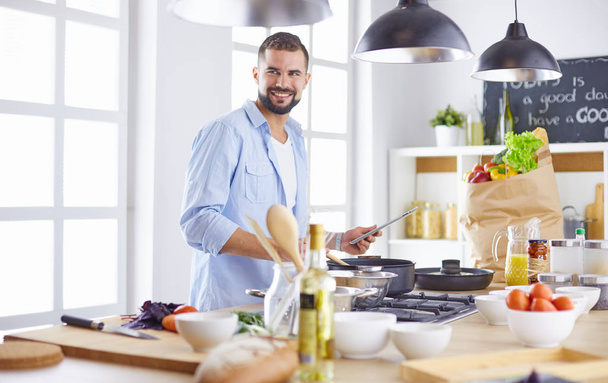 Chef sorridente e confiante em pé na grande cozinha - Foto, Imagem