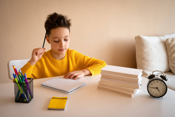 Thinking child bored, frustrated and fed up doing his homework - 写真・画像