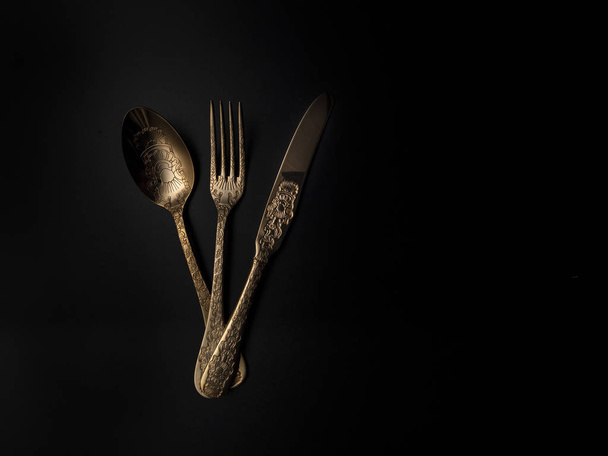 Siyah arka plan ile altın çatal bıçak seti - Fotoğraf, Görsel
