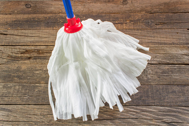 Textile mop on wooden floor background - Photo, Image