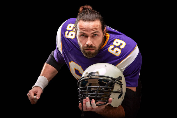 Ritratto di giocatore di football americano con casco in mano primo piano
 - Foto, immagini