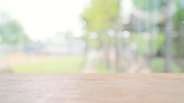Houten bord leeg tafelblad met wazige achtergrond. Perspectief bruin houten tafel over wazig in coffeeshop achtergrond - kan worden gebruikt mock up voor montage producten display of design sleutel visuele lay-out. - Video