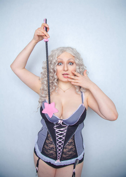 caucasian curvy girl in erotic lingerie with leather bdsm riding crop standing as advanced vanilla person ready for kinky sex on white background - Photo, Image
