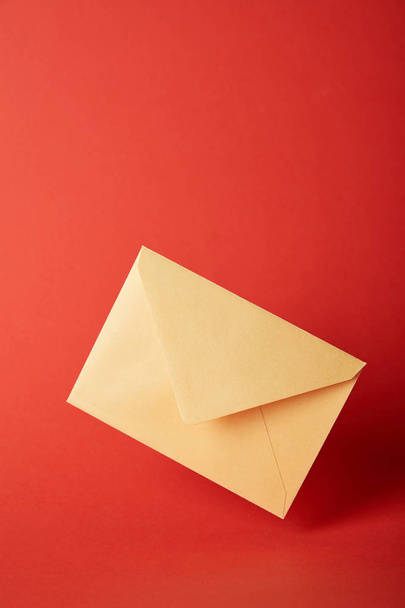 envelope brilhante, colorido e amarelo no fundo vermelho com espaço de cópia
  - Foto, Imagem
