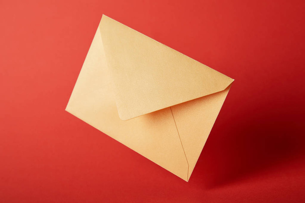 bright, colorful and yellow envelope on red background with copy space  - Φωτογραφία, εικόνα