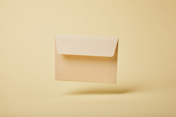 beige and blank envelope on yellow background with copy space  - Photo, Image