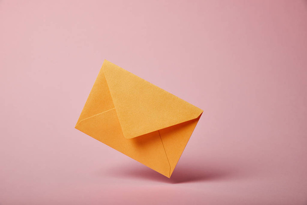 yellow and colorful envelope on pink background with copy space - Fotó, kép