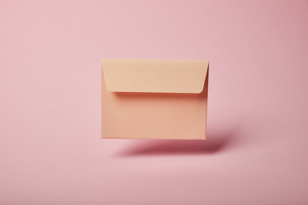 beige and empty envelope on pink background with copy space - Φωτογραφία, εικόνα