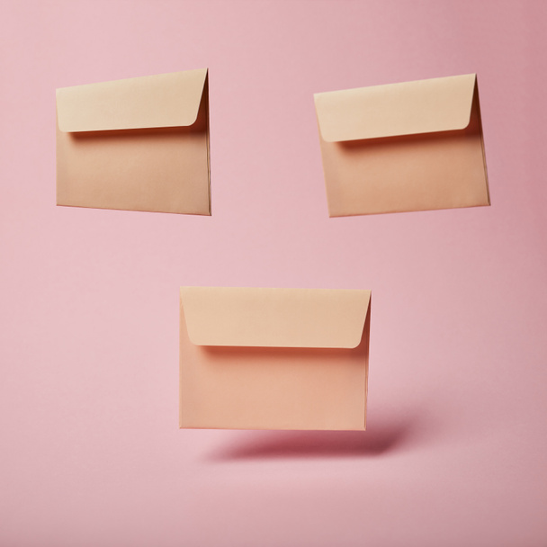 beige envelopes with copy space on pink and pastel background  - Фото, зображення