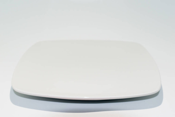 Empty ceramic plate isolated on white background. Square dish - Foto, Imagem