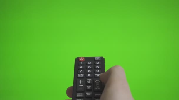 Αρσενική χέρι με κανάλια Tv remote πατώντας πάνω από την πράσινη οθόνη. Θέση για τη διαφήμισή σας. - Πλάνα, βίντεο