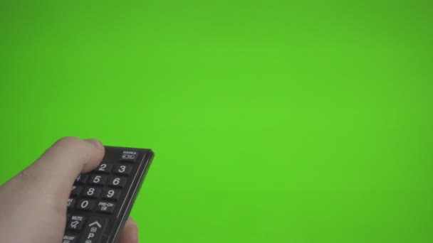 Male hand with remote control turns on the TV over green screen. Place for your advertisement. - Footage, Video