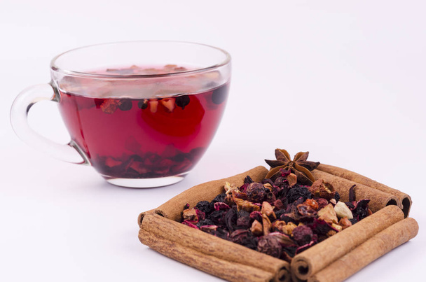 Una tazza di tè alla frutta sullo sfondo di foglie di tè e cannella
 - Foto, immagini