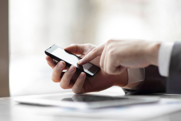 close up.businessman is typing SMS on a smartphone - Фото, зображення