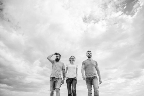 True friendship grow with destiny obstacles. United threesome true friends. Keep moving trough long way. United group purposefully moves forward. Men and woman walks dramatic cloudy sky background - Fotoğraf, Görsel