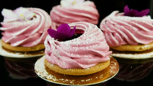紫と白の花で飾られたピンクのマシュマロ クッキーの小さなグループからズーム アウト - 映像、動画