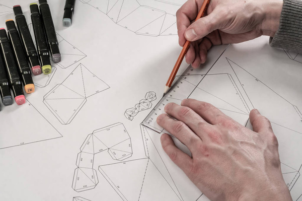 Male designer makes a working drawing. Workplace of a toy design - Zdjęcie, obraz