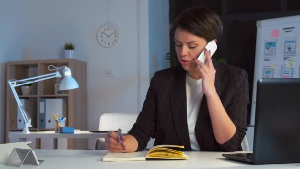 businesswoman calling on smartphone at dark office - Πλάνα, βίντεο