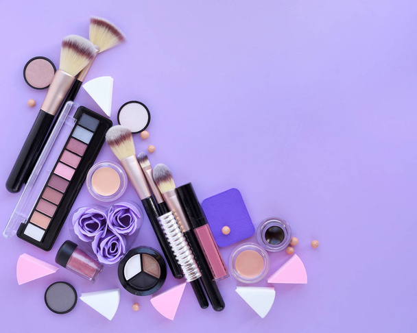 Cepillo de maquillaje y cosméticos decorativos sobre fondo lila
. - Foto, Imagen