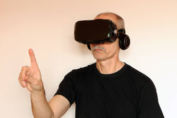 Close-up of a man in a black T-shirt with glasses of virtual rea - Фото, зображення