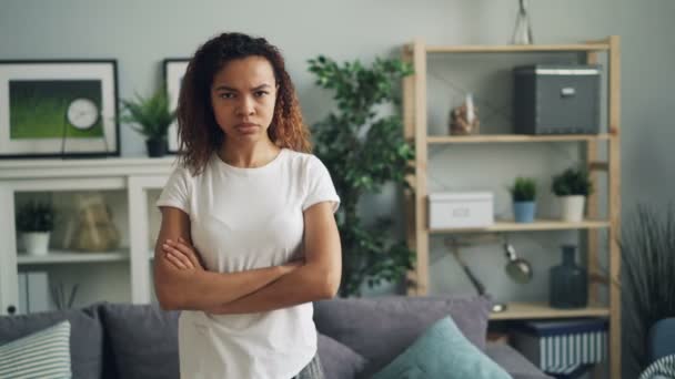 Portrait of upset and offended African American lady standing at home with arms crossed making angry face frowning and looking at camera with indignation. - Materiał filmowy, wideo