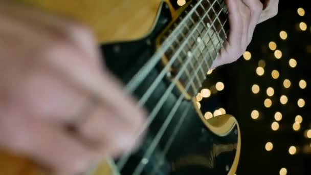 Hudebník hraje na elektrickou kytaru v rozostření hvězdy pozadí - Záběry, video
