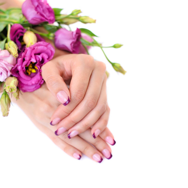 Руки жінки з рожевим французьким манікюром і еустомою квітів
 - Фото, зображення