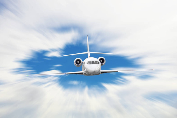 Λευκό αεροπλάνο με το motion blur αποτέλεσμα πετούν πάνω από τα σύννεφα. - Φωτογραφία, εικόνα