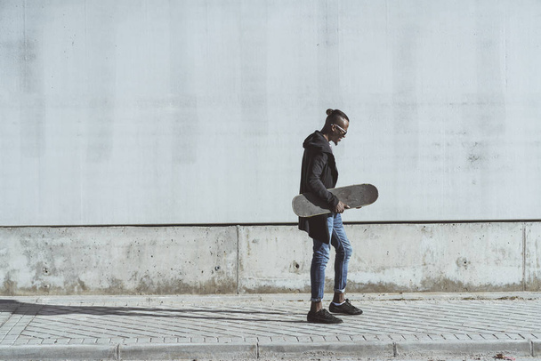 Afrikai fiatalember, birtoklás móka-val gördeszka, az utcán - Fotó, kép