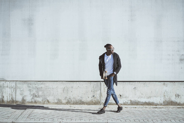 Afrikai fiatalember, birtoklás móka-val gördeszka, az utcán - Fotó, kép