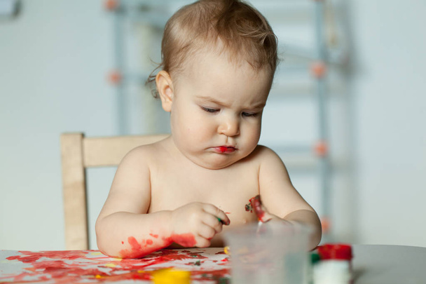 little girl paints in the room, baby got dirty - Фото, изображение