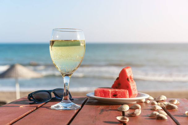 summer, a glass of champagne and fruit against the background of the sea - Fotoğraf, Görsel