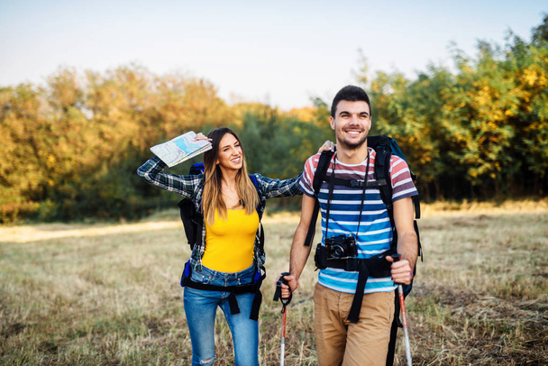 glückliches junges Paar mit Rucksack auf der Wiese - Foto, Bild