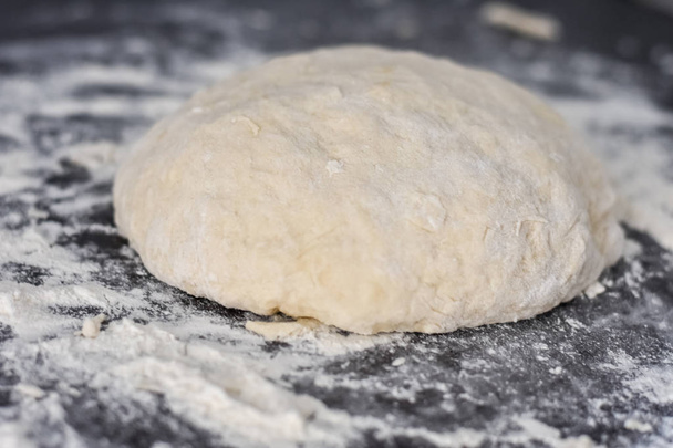 dough on a black table, homemade food - Фото, изображение