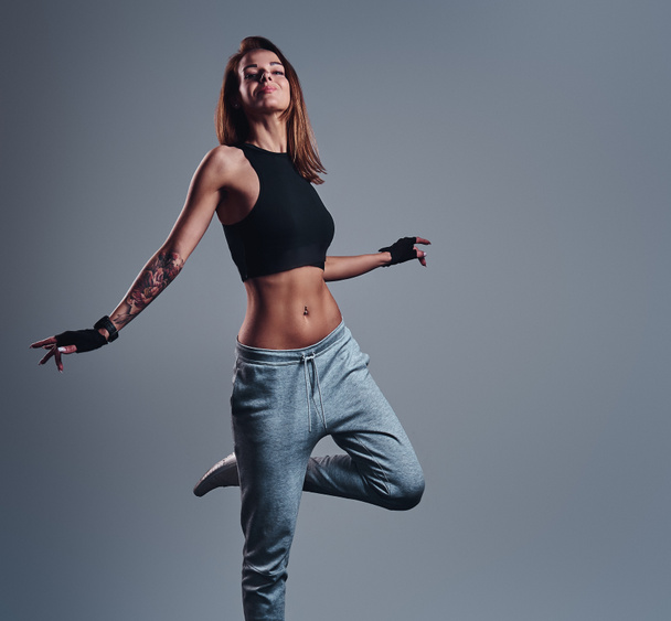 Egy vékony fitness lány visel pózol egy stúdió sportruházat teljes hosszúságú portréja. - Fotó, kép