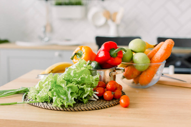 healthy foods are on the table in home kitchen. Fresh vegetables and utensils for cooking on wooden table. Healthy food, cooking concept - Photo, Image