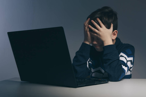 Lähikuva kuva kiusaamisesta teini poika tunne järkyttynyt infront tietokoneen. Stressaantunut surullinen poika kiusaa luokkatovereitaan
. - Valokuva, kuva