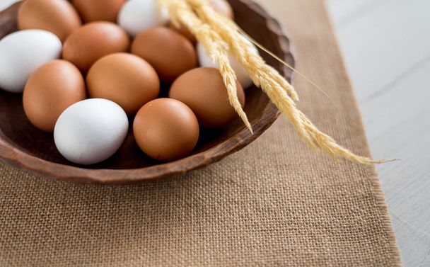 Ovos frescos em cesta de vime na mesa de madeira Prepare ovos de galinha e batedor de ovo para cozinhar ou padaria pode usar para fundo ou papel de parede
 - Foto, Imagem