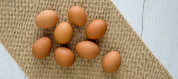 Ovos frescos em cesta de vime na mesa de madeira Prepare ovos de galinha e batedor de ovo para cozinhar ou padaria pode usar para fundo ou papel de parede
 - Foto, Imagem