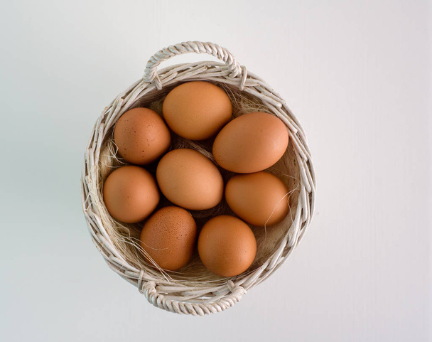 Œufs frais dans un panier en osier sur une table en bois Préparer des œufs de poulet et fouet d'œufs pour la cuisson ou la boulangerie peut utiliser pour le fond ou le papier peint
 - Photo, image
