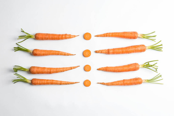 Flat lay composition with ripe fresh carrots on white background - Фото, изображение