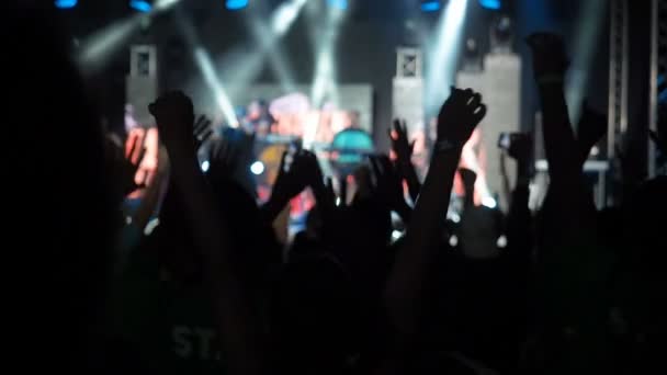 Zeitlupe Video Hintergrund glückliches Publikum springen Rosetten Hand Palme Rock Gruppe Konzerthalle Silhouetten tanzende Menschen applaudieren erhobenen Händen nach oben Menge applaudiert Rhythmus Musik Musiker führen Bühne - Filmmaterial, Video