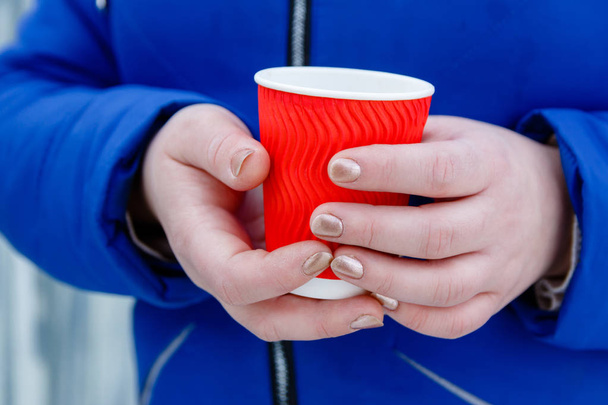Bebida caliente café en taza de papel en las manos de las mujeres de cerca
 - Foto, imagen