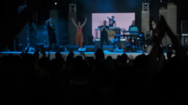 Pomalý pohyb, že Video na pozadí umělec publikum skákání Raisies rukou rockové skupiny koncertní síň siluety tančící lidé tleskají zvyšování ruce vzhůru dav tleská rytmus hudby muzikanti provést fázi - Záběry, video