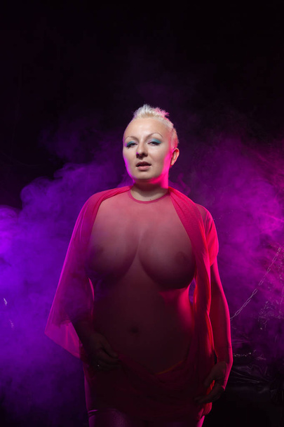 chubby naked woman with short white hair wearing transparent mesh pink catsuit  - Foto, imagen