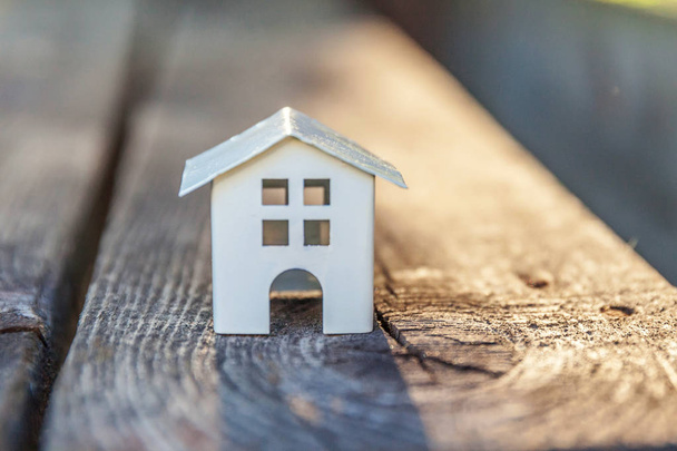 Miniaturní bílý toy modelu dům dřevěné pozadí. Eco Village, abstraktní pozadí životního prostředí - Fotografie, Obrázek
