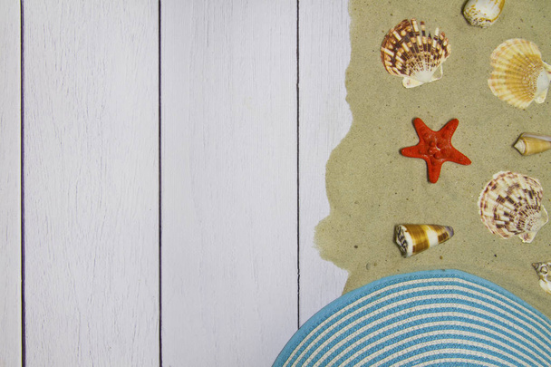 Conchas de mar, estrellas, sombrero sobre un fondo de madera clara con arena, vista superior
 - Foto, Imagen